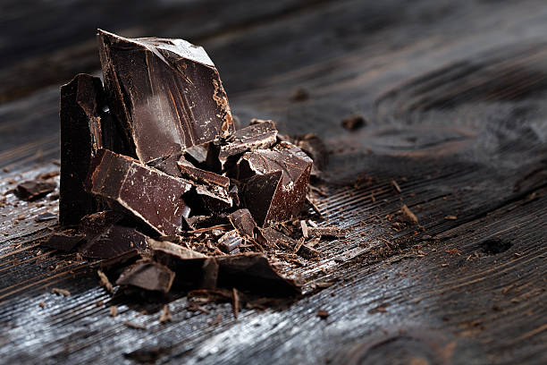 istock Broken dark chocolate on a wooden table 513446254
