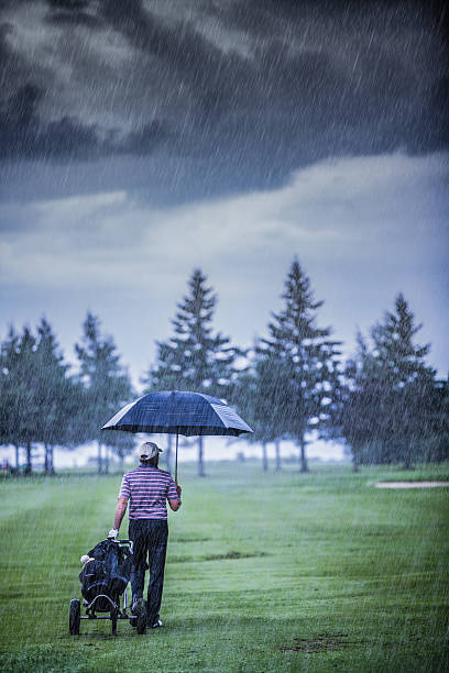 Golfer on a Rainy Day Leaving the Golf Course stock photo