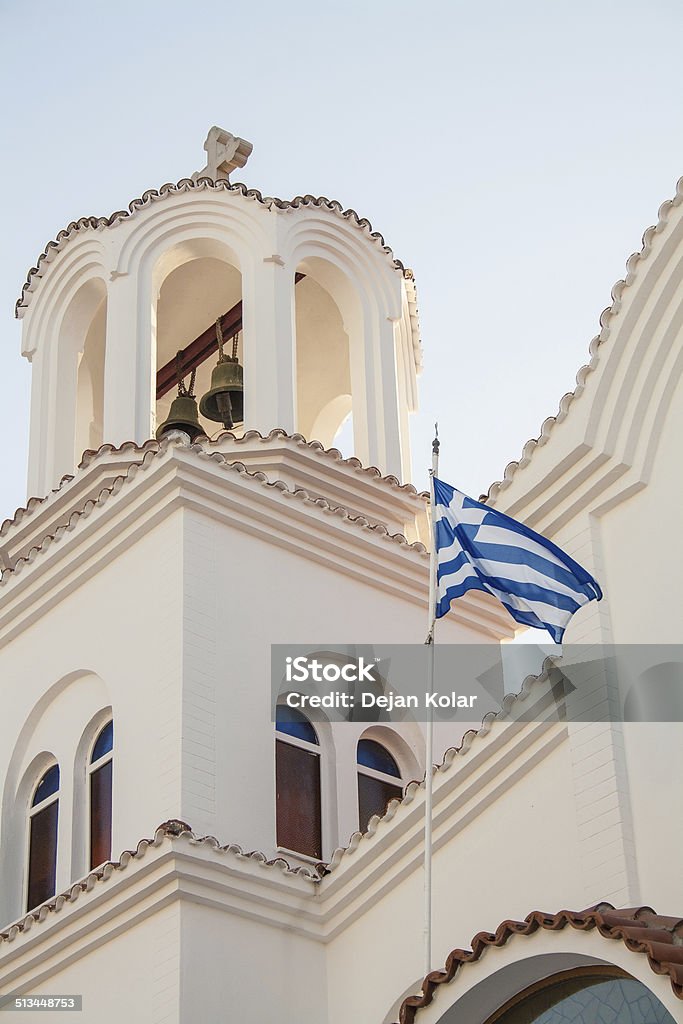 Welcome to Greece Bell tower of Orthodox church with Greek flag in foreground. Architecture Stock Photo