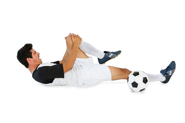 piłka nożna gracz w pozycji leżącej i krzyczy w bólu - lying down men isolated young adult zdjęcia i obrazy z banku zdjęć