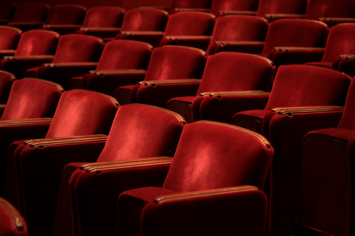 Many rows of theater seats from the side with copy space