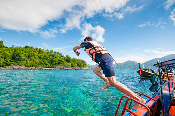 istock Man jumping off the boat into the ocean 513471100