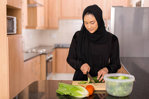 muslim woman chopping vegetables pretty muslim woman chopping vegetables in kitchen pics of a cute muslim outfits stock pictures, royalty-free photos & images