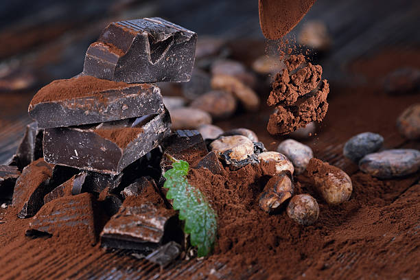 istock Dark chocolate pieces and cocoa beans on a wooden table 513471522