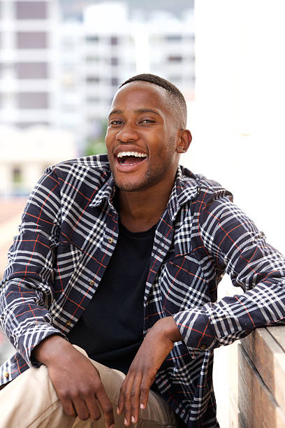 istock Smiling young african man sitting on a bench outdoors 513472200