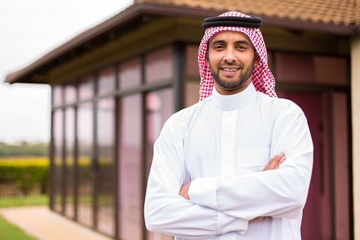 modern young arabian man with arms crossed outside his house