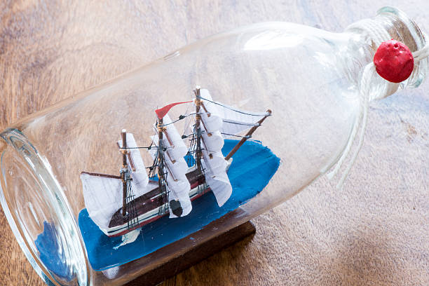istock ship in a bottle on wooden table 513473588