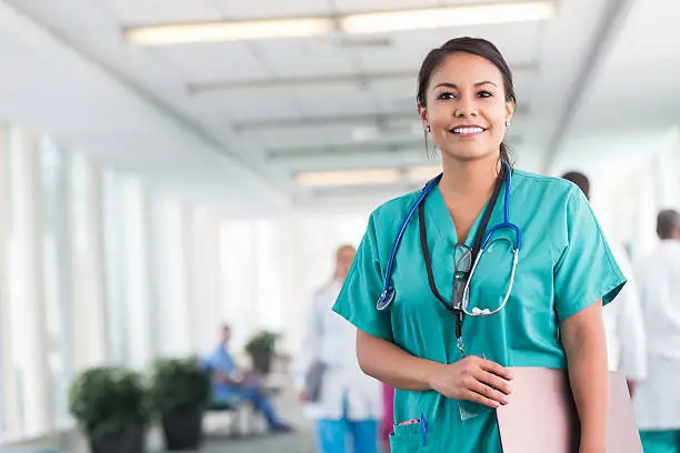Confident hospital nurse smiling while working in modern hospital