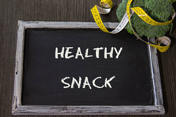 istock Healthy snack text on blackboard with broccoli and tape measure 513475510