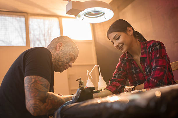 istock Smiling young woman getting new tattoo on arm. 513476462