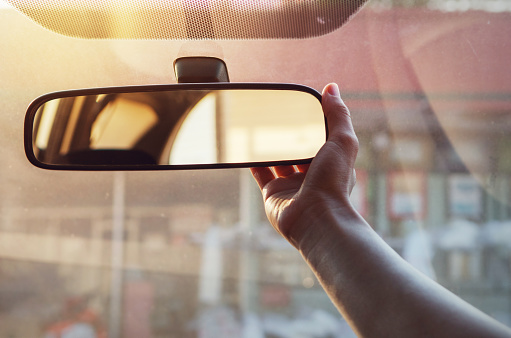 Teenage driver adjusting the rear view mirror