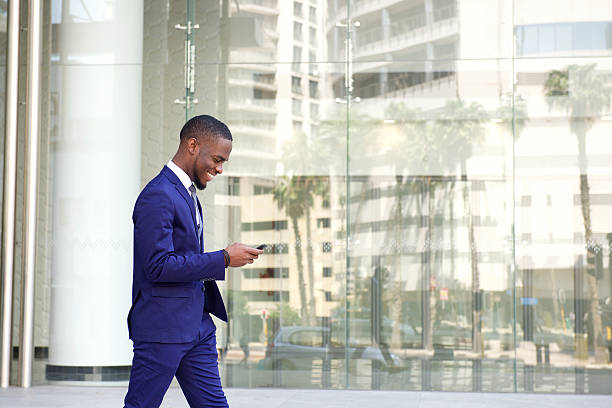 istock Young businessman walking and using cell phone 513479342