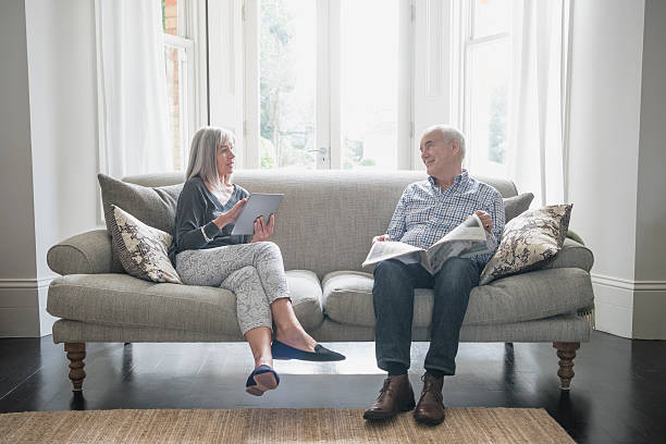 Senior couple sitting on the sofa at home, talking