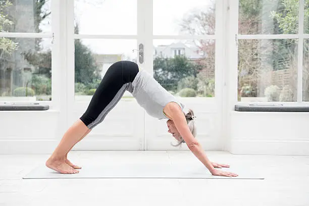 Photo of Senior woman in downward dog position