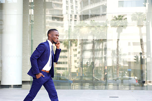 istock Happy young man walking and talking on mobile phone 513481568