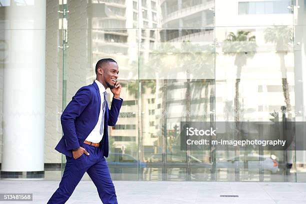 Happy Young Man Walking And Talking On Mobile Phone Stock Photo - Download Image Now