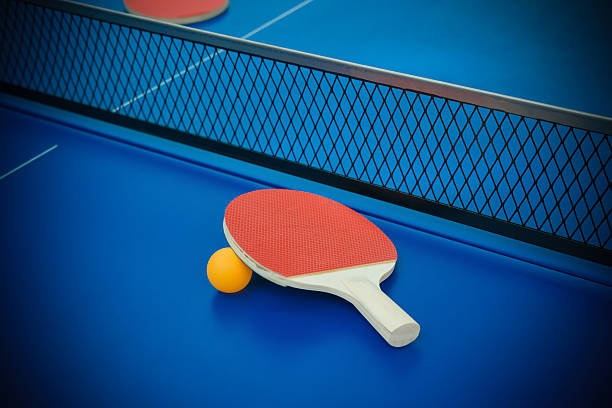 istock pingpong rackets and ball highlighted on a blue pingpong table 513482218