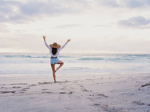 bas de bikini fille pratiquant du yoga sur la plage - usa travel sunset summer photos et images de collection