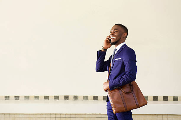 istock Smiling young businessman walking and talking on mobile phone 513484924