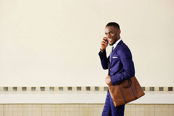 istock Laughing young business man walking and talking on cell phone 513485246