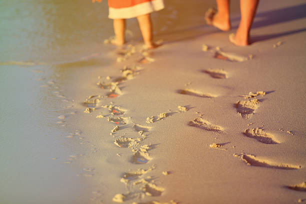 mutter und tochter zu fuß auf den strand verlassen spuren im sand - footprint sand sea beach stock-fotos und bilder
