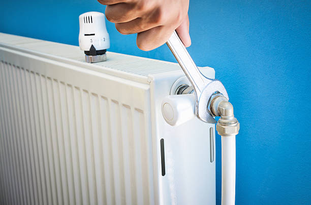 homem instalando radiator válvula close-up - heating engineer - fotografias e filmes do acervo