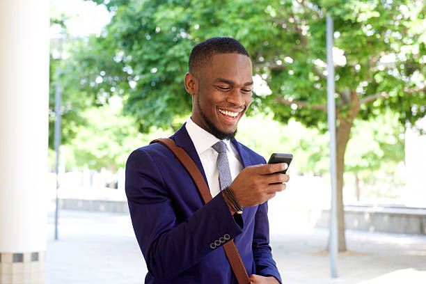 istock Smiling young businessman looking at mobile phone 513488162