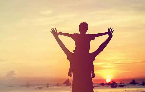 Photo of father and son on sunset beach