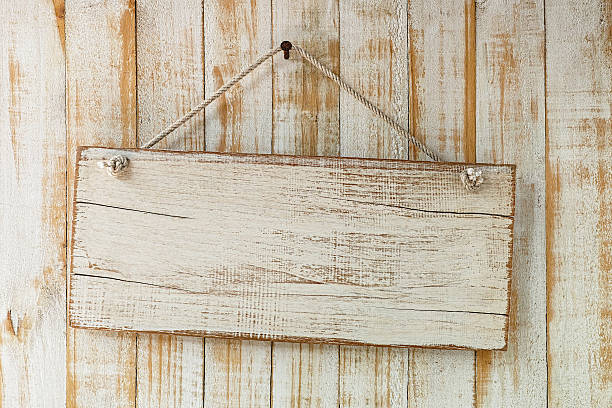 istock Old weathered white wood signboard hanging from an old nail. 513489540