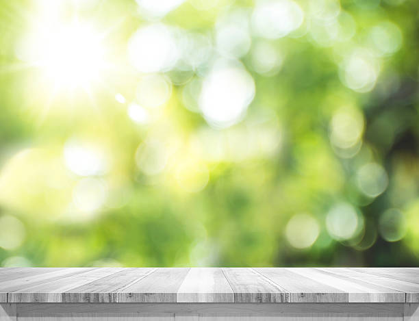 istock plank white wood table top with blur green tree bokeh 513489828