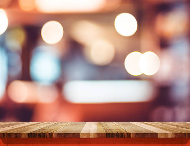 istock Empty wood table top with red trim at blur restaurant 513489902