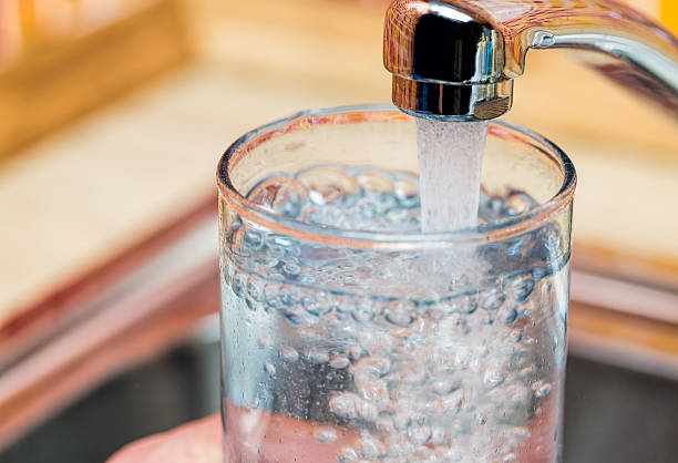 istock Filling up a glass with drinking water from kitchen tap 513491906