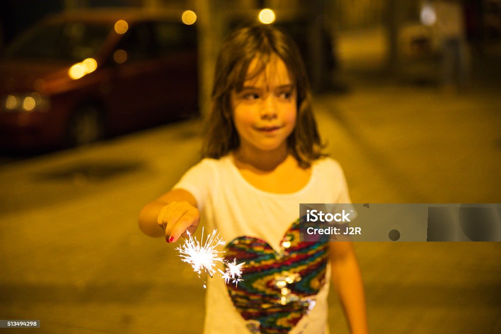 Little girl with a sparkler, Barcelona Little girl with a sparkler at night to celebrate the festivity of Sant Joan on a street in Barcelona, Catalonia, Spain Barcelona - Spain Stock Photo