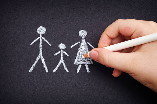 istock Child drawing family on black paper 513498030