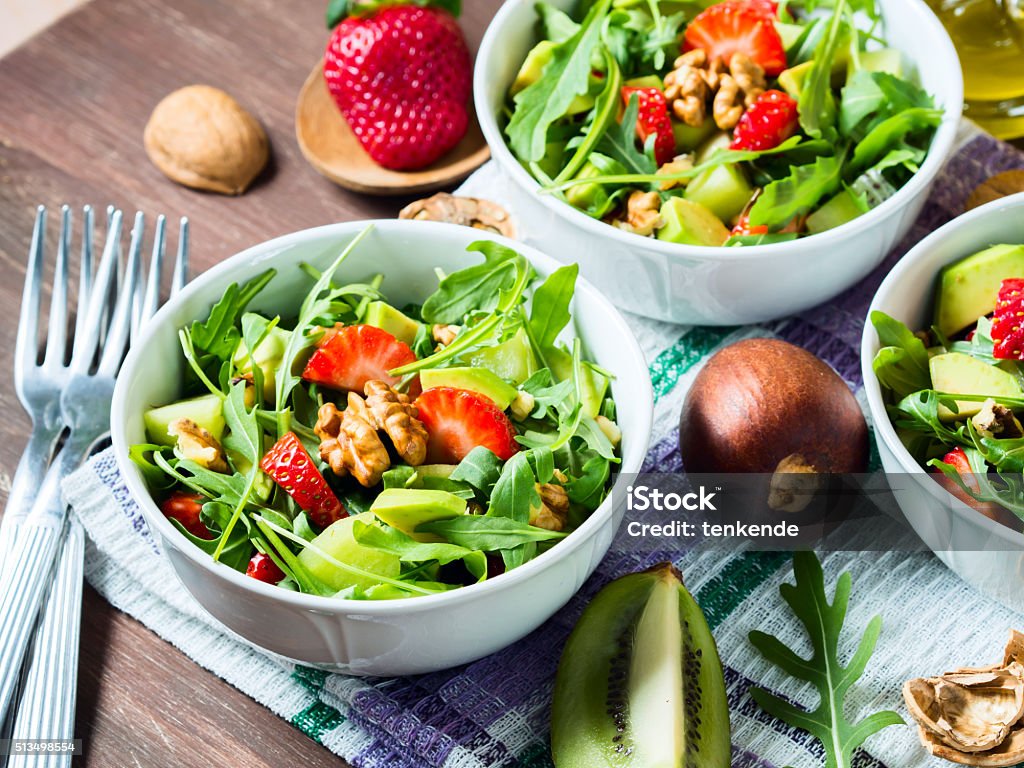 Avocado salad with strawberries and walnuts Avocado salad in bowls with avocado, strawberries, kiwi, walnuts, arugula and olive oil Avocado Stock Photo