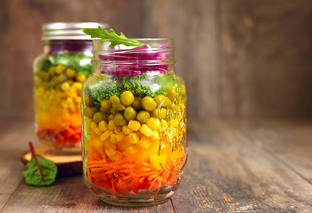 Fresh vegtable salad in a mason jar on an old wooden table.Rustic style.