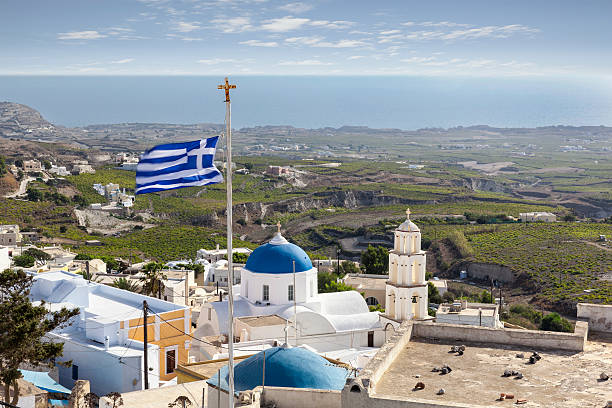 Rooftop view of Pyrgos in Santorini with greek flag stock photo