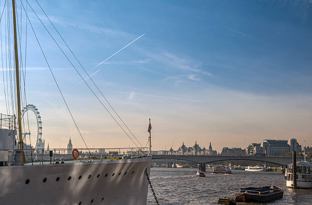 London, England - November 30, 2012: The HMS Wellington (a convoy escort ship in the North Atlantic during Second World War), the River Thames, the Waterloo Bridge and the North Bank on a cold winter morning.