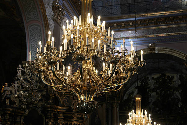 large spider chandelier hanging high in the church and enlightens the dark room of an old church