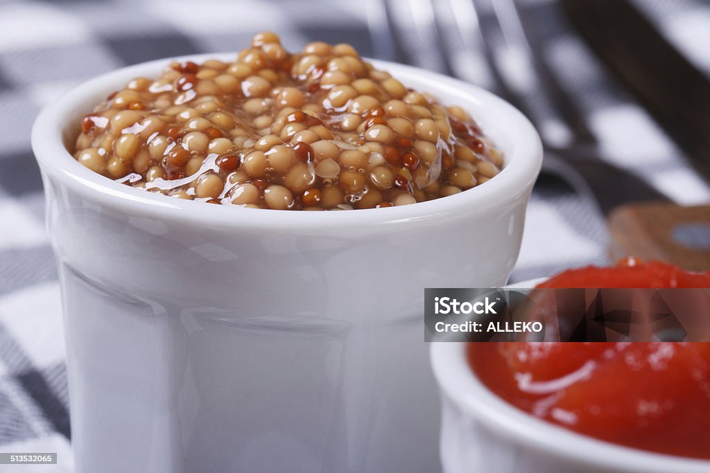 Dijon mustard and tomato ketchup on the table closeup. Dijon mustard and tomato ketchup on the table closeup. macro Backgrounds Stock Photo