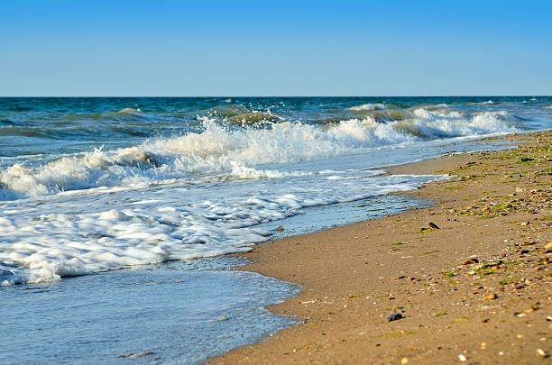 Sea waves wash the beach against a blue sky Sea waves wash the beach against a blue skySea waves wash the beach against a blue sky odessa beach stock pictures, royalty-free photos & images