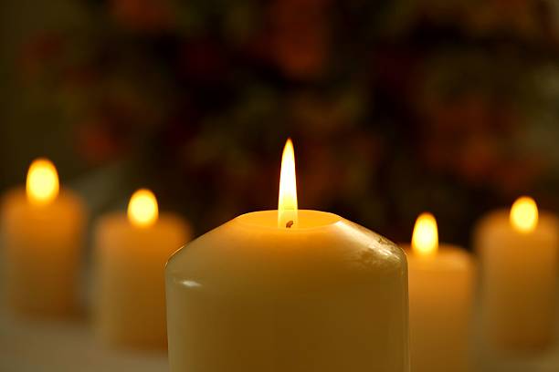istock Burning candles against blurred flower background 513535480