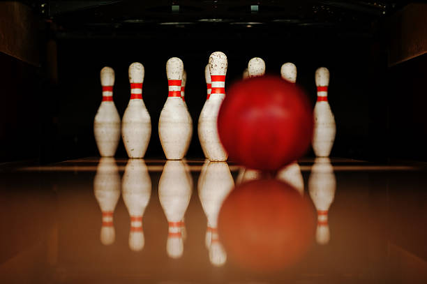 istock Ten white pins in a bowling alley with ball hit 513538556