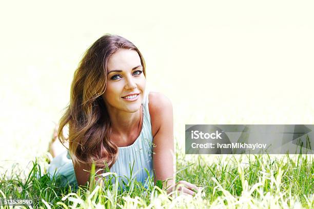 Young Woman In Blue Dress Lying On Grass Stock Photo - Download Image Now - Adult, Adults Only, Beautiful People