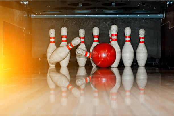 istock Ten white pins in a bowling alley with ball hit 513540290