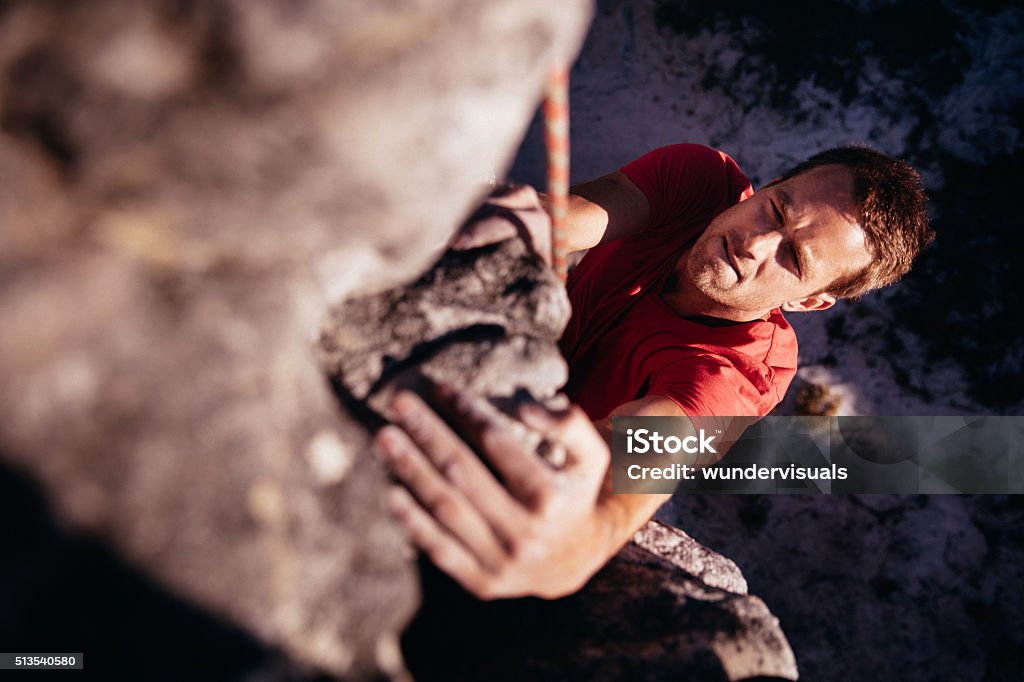 Konzentriert Felsklettern halten auf Griffigkeit beim hängen von Felsblock - Lizenzfrei Felsklettern Stock-Foto