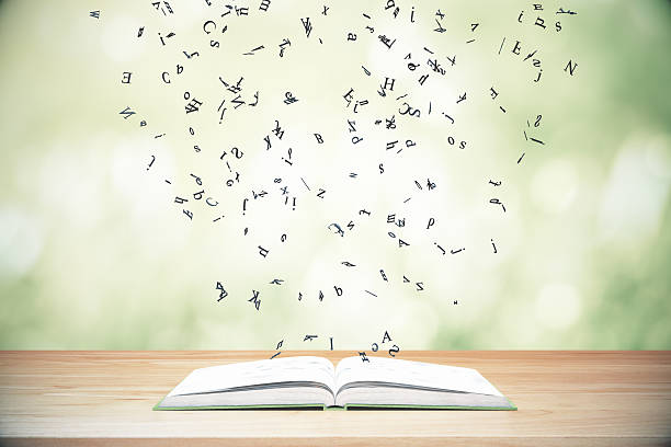 istock Flying letters from the opened book on wooden table 513541602