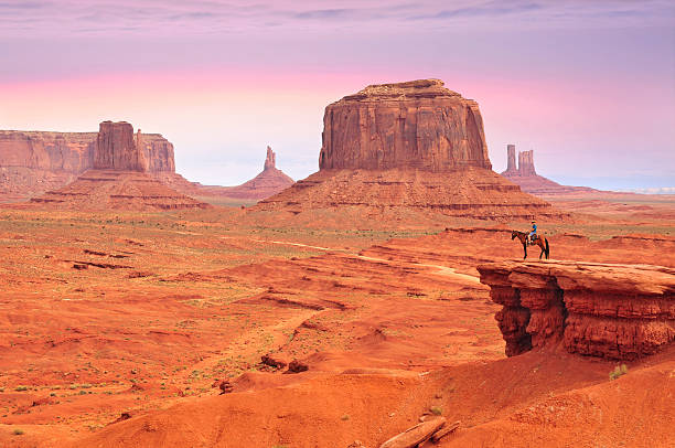 Man on a horse in Monument Valley Man on a horse, view from John Ford's Point in Monument Valley with the West Mitten Butte and the Merrick Butte in Utah-Arizona border, United States of America. butte rocky outcrop photos stock pictures, royalty-free photos & images