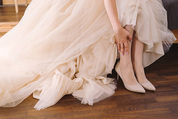 istock bride in beige wedding dress put on her shoes 513547224