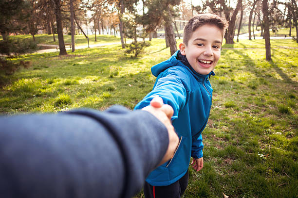Boy with father walking through the park on a sunny day